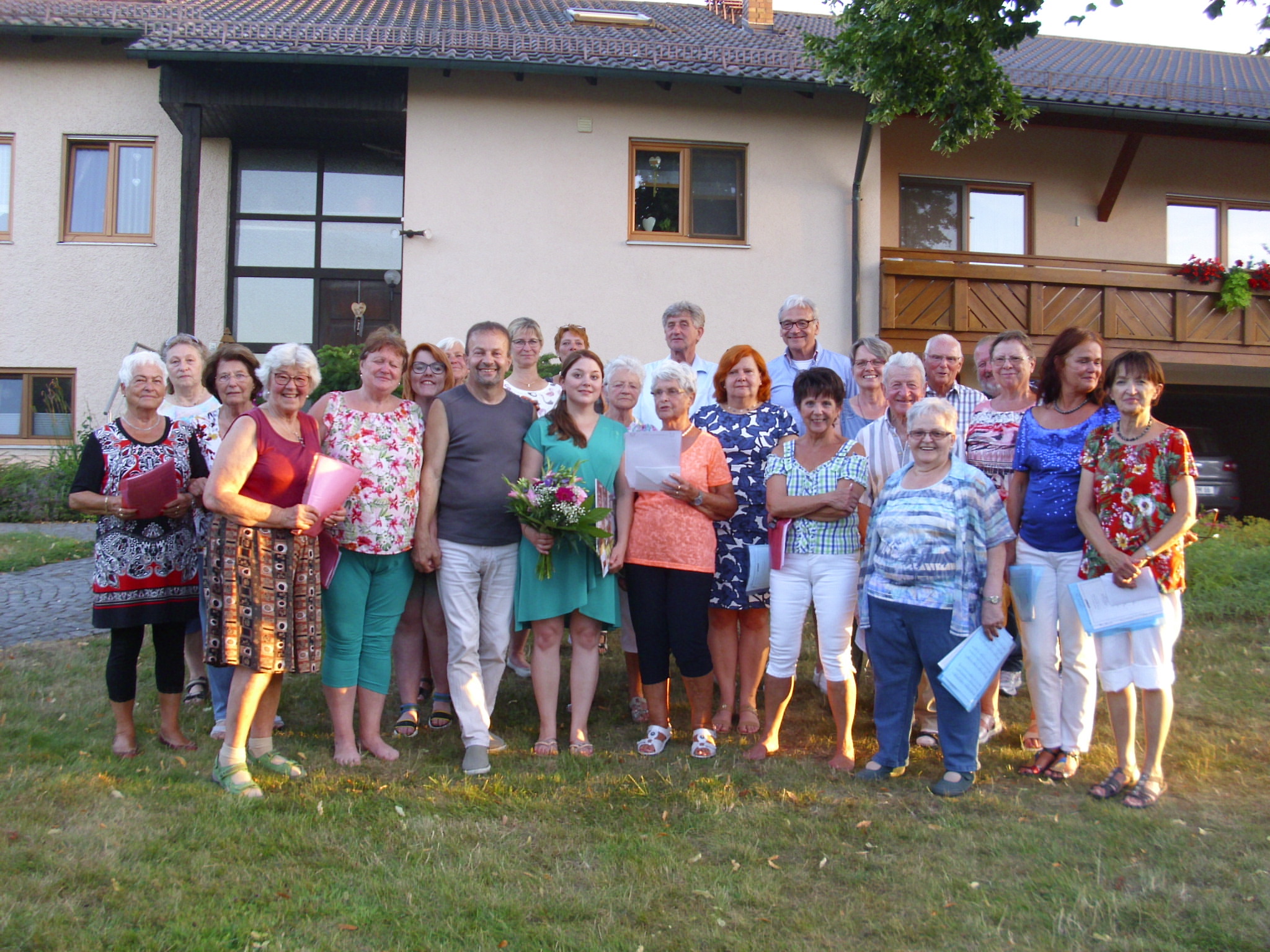 2019 Juli – Verabschiedung der Dirigentin: Gruppenfoto mit den aktiven Sängerinnen und Sängern bei der Verabschiedung der damaligen Dirigentin Christina Müller im Rahmen des Kameradschaftsabends (= Jahresabschlussfest vor der Sommerpause im Juli) im Garten eines aktiven Sängers. (Foto: Dieter Knoll)