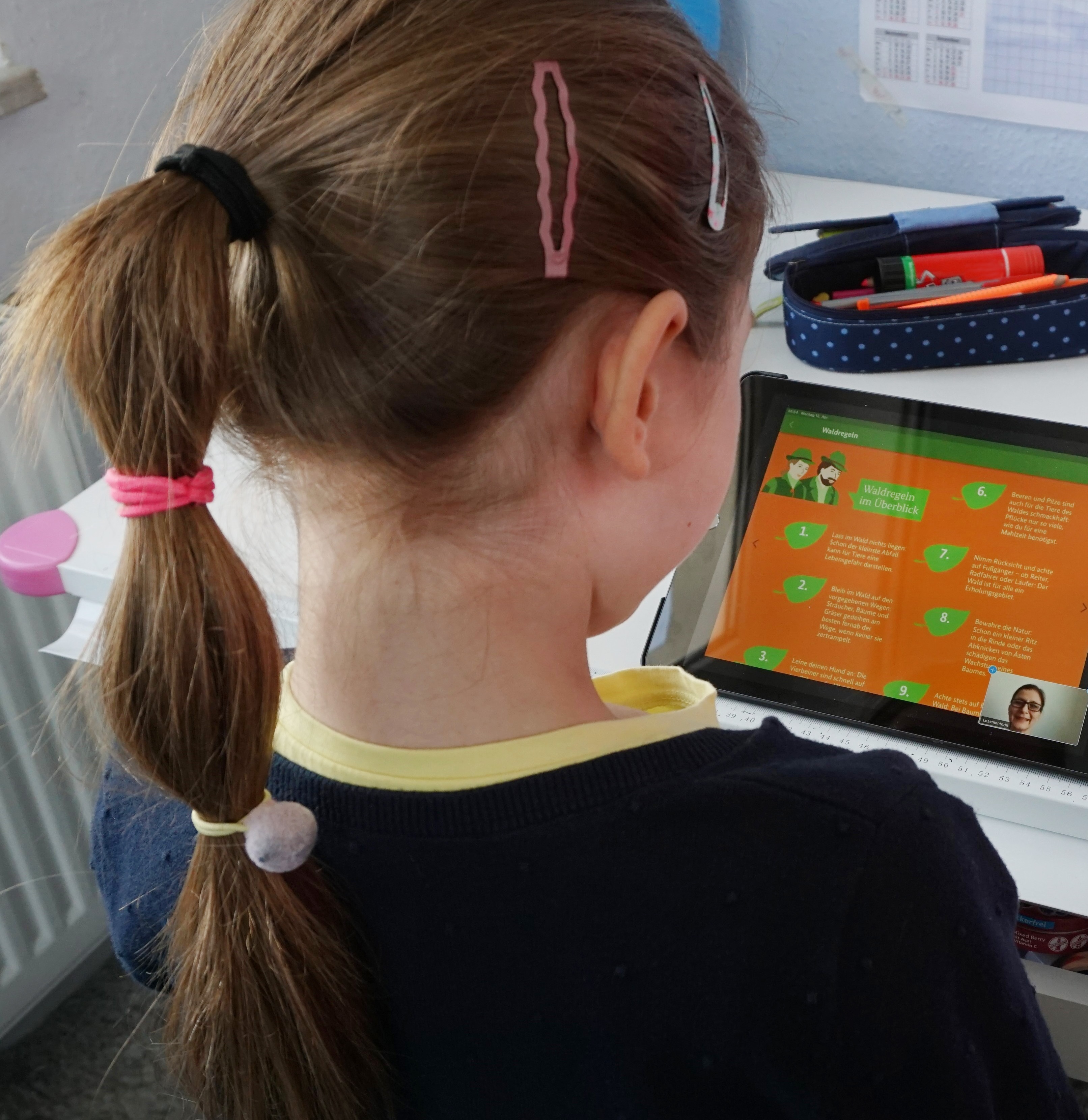 Mädchen sitzt vor Tablet und liest Mädchen sitzt vor Tablet und liest