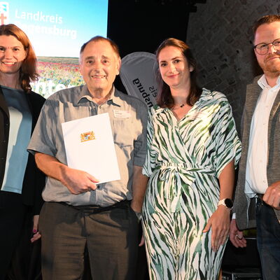 Bild vergr&ouml;&szlig;ern: Frau Landrätin Schweiger und Vertreter des Landratsamts mit Herrn Schiegl auf der Bühne