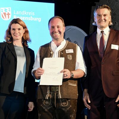 Bild vergr&ouml;&szlig;ern: Frau Landrätin Schweiger neben Ehrenamtlichen und Bürgermeister auf der Bühne