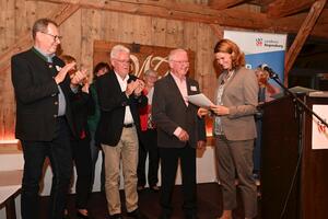 Bild vergr&ouml;&szlig;ern: Frau Landrätin Schweiger mit Teilnehmenden auf der Bühne Ehrenamtsabend 2024