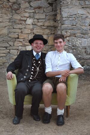 Bild vergr&ouml;&szlig;ern: Zwei Männer sitzen auf einem gelben Sofa