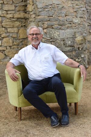 Bild vergr&ouml;&szlig;ern: Älterer Mann mit Brille auf dem gelben Sofa beim Ehrenamtsabend 2022